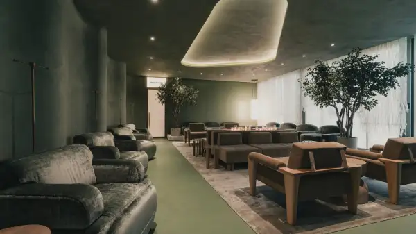 Modern wellness lounge with soft lighting, green tones, and comfortable seating