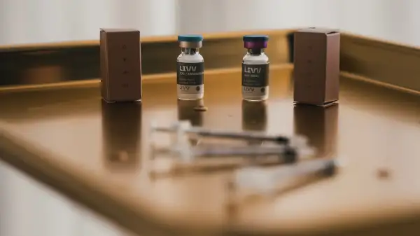 Medical vials and syringe on a stainless steel tray